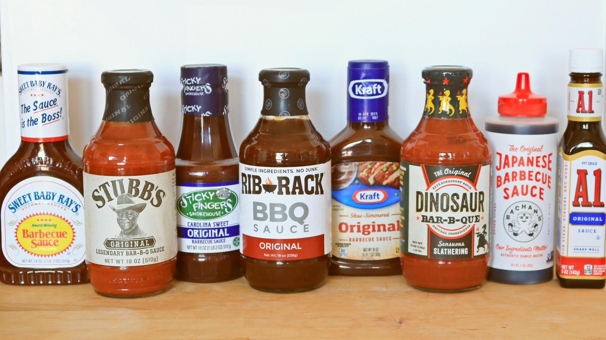Huit sauces barbecue alignées sur un comptoir.