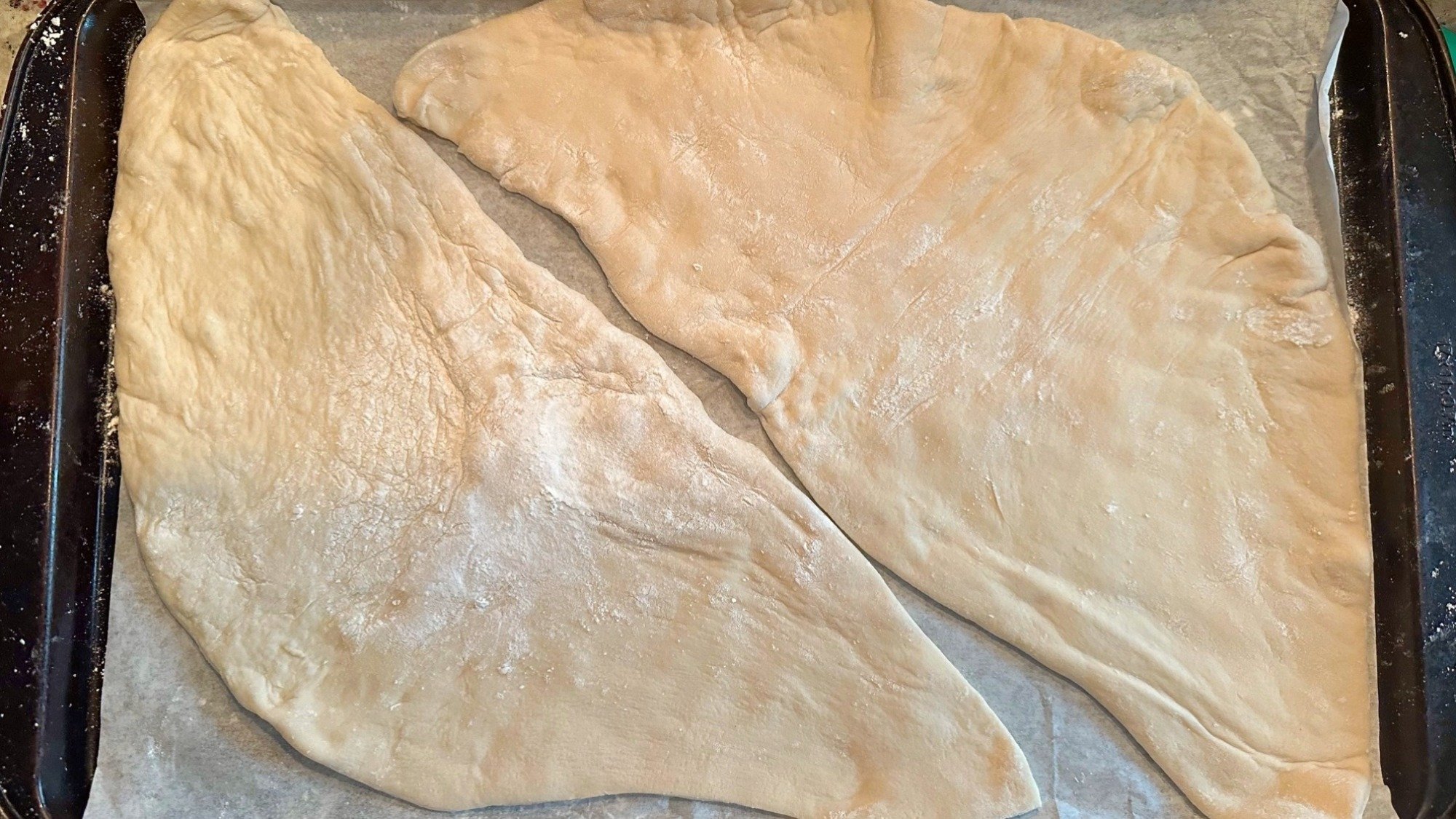 Deux morceaux de pâte à pizza sur un plateau