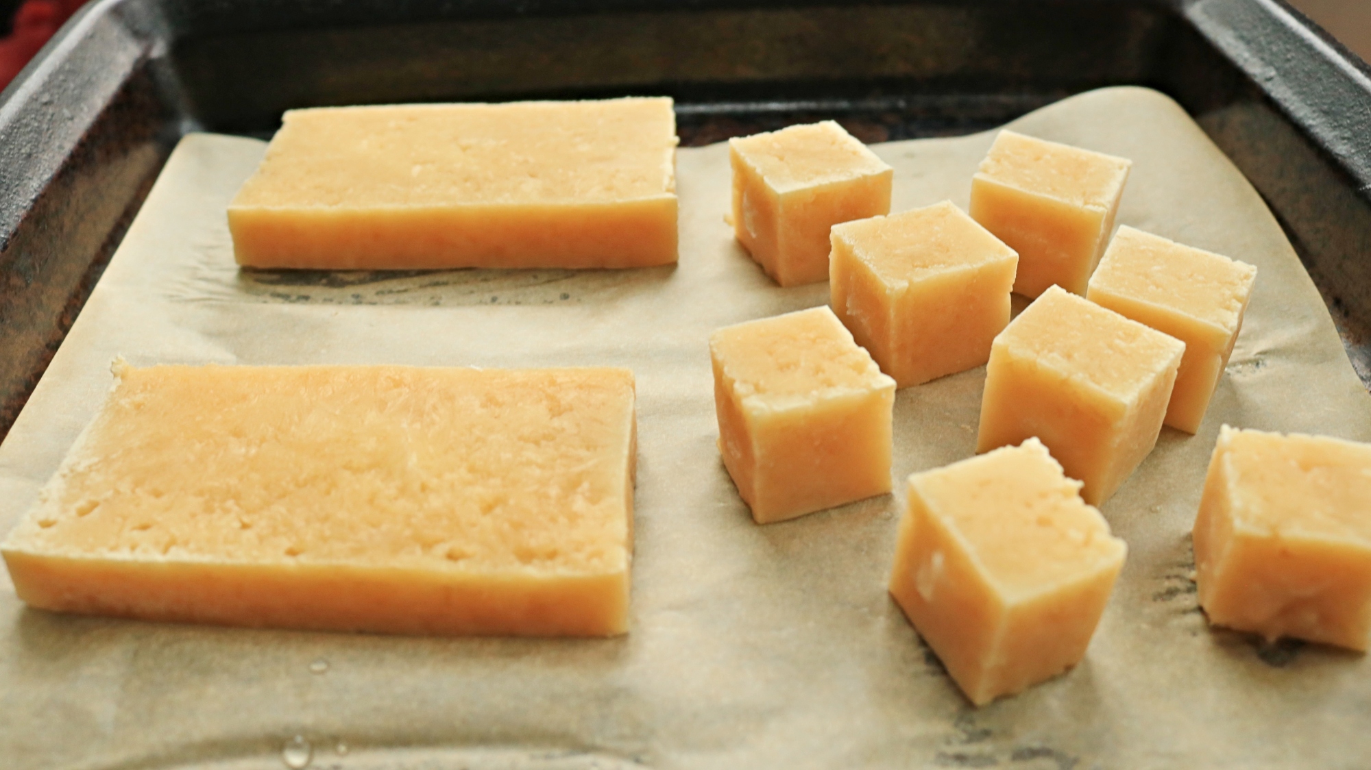 Deux dalles et plusieurs blocs de tofu congelé sur une poêle.