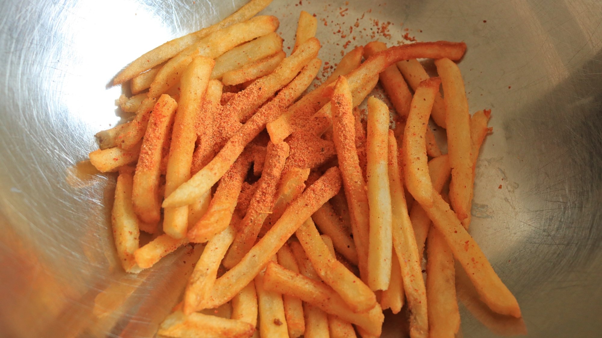 Des frites avec une poudre rouge jetée sur le dessus.